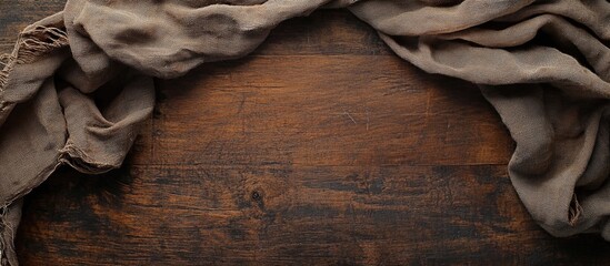 Poster - Textured brown fabric draped on a rustic wooden surface with Copy Space for text placement