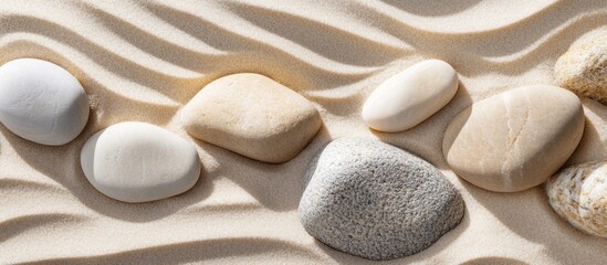 Poster - Smooth stones arranged on rippled sand surface with soft shadows