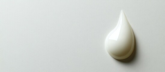 Poster - White cream droplet on a smooth light gray background with copy space for text placement