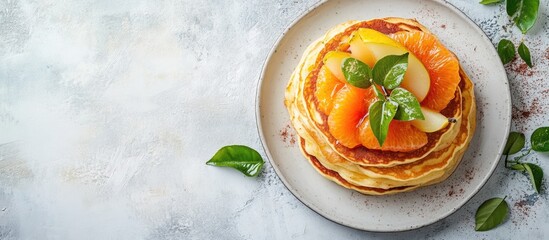 Poster - Stack of pancakes with fresh fruits including peaches and apples on a beige plate with green leaves on a textured background Copy Space