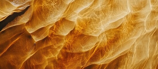 Poster - Abstract textured background of golden and amber flowing waves with light reflections