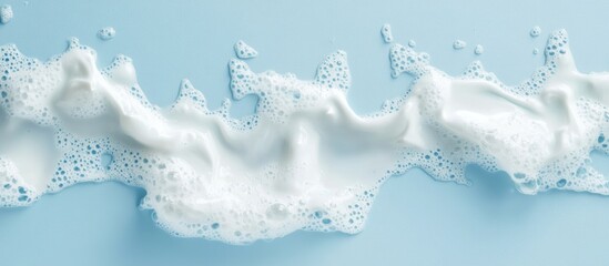 Poster - White foam waves with droplets on a soft blue background ideal for creating clean and refreshing designs with ample text space