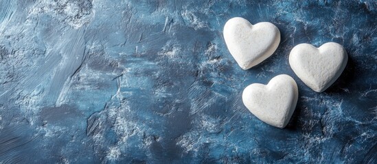Poster - White hearts on textured blue stone background for Valentine's Day with ample space for text and design elements.