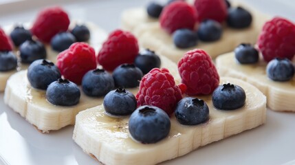 Poster - Colorful Banana Slices Topped with Fresh Blueberries and Raspberries on a White Plate