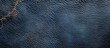 © Rizvan - Close-up of textured dark blue leather surface with visible creases and natural patterns