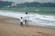 © alexkoral - back of dad with a child boy son are walking along the beach by the sea on a summer vacation