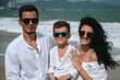 © alexkoral - happy young family with a child son on the beach by the sea in summer on vacation