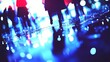 © huhu - Blurred silhouettes of people walking at night, city reflections on wet ground.