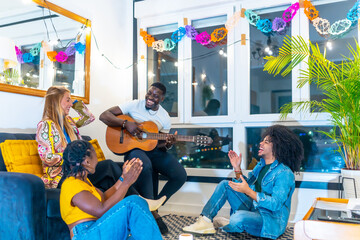 Wall Mural - Friends clasping while man playing guitar at home at night