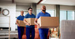 © Andrey Popov - Professional Movers Smiling While Holding Boxes