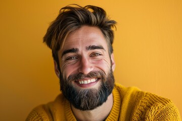 Close up portrait of a cheerful bearded man wearing a yellow sweater, expressing happiness and positivity against a vibrant yellow backdrop