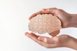 © Ева Поликарпова - A person holds a puzzle piece with a brain symbol, representing problem-solving or intellectual pursuits