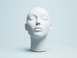 © Tanakrit - A minimalist white mannequin head with closed eyes, showcasing a serene and abstract aesthetic against a soft background.