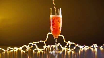 Poster - A vivid advertisement composition showing a tall glass filling with bright orange bubbles, accented by swirling ribbons and sparkling lights.