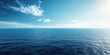 Calm ocean view with clear blue skies and gentle waves under the sunlight.