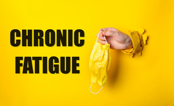 Person holding a yellow mask with the words Chronic Fatigue written below
