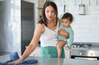 © peopleimages.com - Mother, cloth or cleaning with baby in kitchen for sanitary, disinfection or hygiene at home. Mom, little kid or wiping surface or counter with toddler for cleanliness, housekeeping or house chores
