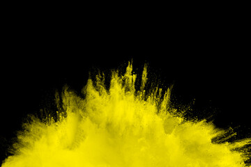 Wall Mural - yellow explosion of powdery dust is blowing out of a black background. the yellow color of the dust 