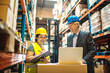 © Davor - Warehouse manager and female worker discussing inventory logistics with clipboard and laptop