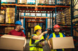© Davor - Warehouse workers carrying boxes while supervisor giving instructions in storage facility