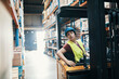 © Davor - Female worker operating forklift in large warehouse