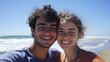 © Sawyer0 - A joyful young couple takes a selfie on a sunny beach, their beaming smiles capturing the essence of love and happiness with the ocean waves in the background.