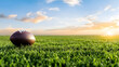© Nadiyah - Sunset Football Field Lone ball on lush grass at sunset, peaceful sky backdrop; ideal for sports, game promotion