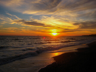 Wall Mural - Sea waves on sea sand against orange sunset in summer	
