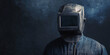 © Ірина Пальцева - A welder wearing a dark protective helmet and suit is surrounded by smoke, representing industrial craftsmanship and safety precautions in metalworking environments.