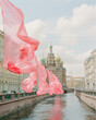 Art installation of flowing pink fabric above a canal with the Church of the Savior on Spilled Blood in the background, Saint Petersburg, Russia.