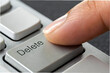 © Butsarakham - A close-up of a finger pressing the 'Delete' key on a keyboard, symbolizing the action of removing or erasing content.