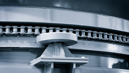 Poster - A metal chain is connected to a metal plate. The chain is visible from the side, and it is quite long. The plate is also made of metal