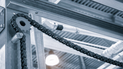 Poster - A chain is attached to a metal structure. The chain is black and silver