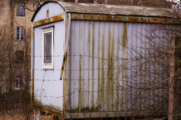 Poster - A small white building with a broken window, suitable for use in historical or abandoned place scene.