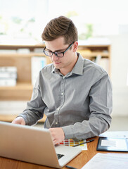 Man, laptop and web design with color palette at office, startup and reading documents at company. Person, pc and notes for website development with typing, review or feedback at creative agency