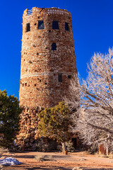 Wall Mural - A tall tower made of stone with a blue sky in the background