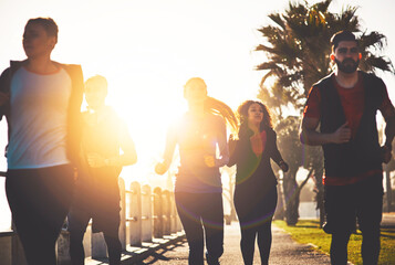 Poster - People, fitness or running with sunset for cardio workout or exercise together on promenade by beach. Active team, community or group of runners in race for sprint or marathon on sidewalk by ocean