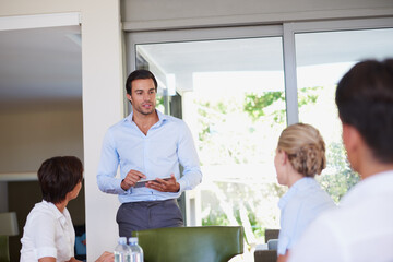 Aufkleber - Man, tablet and presentation with business people in boardroom, notes or brainstorming at insurance agency. Person, speaker and touchscreen with group for proposal, meeting or app for feedback at job