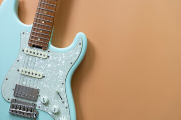 Wall Mural - Electric guitar on yellow table background, close up music concept