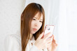 © Faula Photo Works - スマートフォンを持って悩む女性