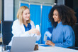 © Phushutter - A young African American patient consults with a young Russian medical doctor about her immune system and vitamin intake. They discuss patient medical history,  vitamin and pill bottles on the desk.
