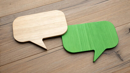 Two wooden speech bubbles, one natural wood and one green, resting on a wooden background The image represents communication, dialogue, or discussion in a simple and modern way,cloud, balloon, dialogu