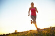 © peopleimages.com - Athlete fitness, woman and running outdoor for competition training, healthy body or cardio challenge. Mockup, blue sky and person exercise on low angle for morning jog, workout performance or energy