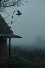 Wall Mural - old street lamp in the fog in an abandoned village, autumn