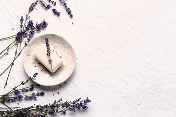 Wall Mural - Dish with soap and and lavender flowers on light background