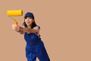 Wall Mural - female asian painter with roller on brown background