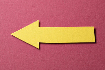 Poster - Yellow cut out blank paper cardboard arrow direction sign with copy space for text on red background, flat lay top view pointing symbol conceptual message backdrop