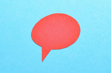 Poster - Red cut out blank paper speech bubble of round shape with copy space for text on blue background, flat lay top view conceptual backdrop