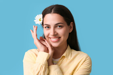 Sticker - Beautiful young happy woman with daisy flower on blue background