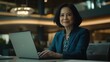 © STwul - Confident businesswoman working laptop modern office lobby